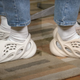 YouTuber Brad Hall compares authentic Yeezy Foam Runners, left, to an approximately $20 pair of knockoffs (right).